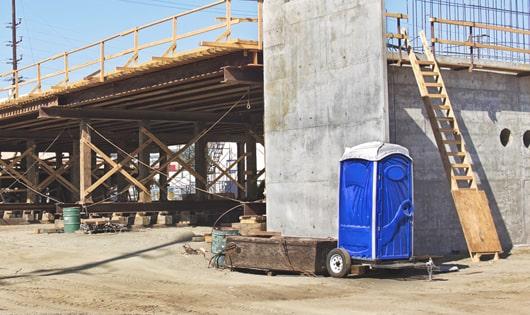 row of portable toilets on a busy work site